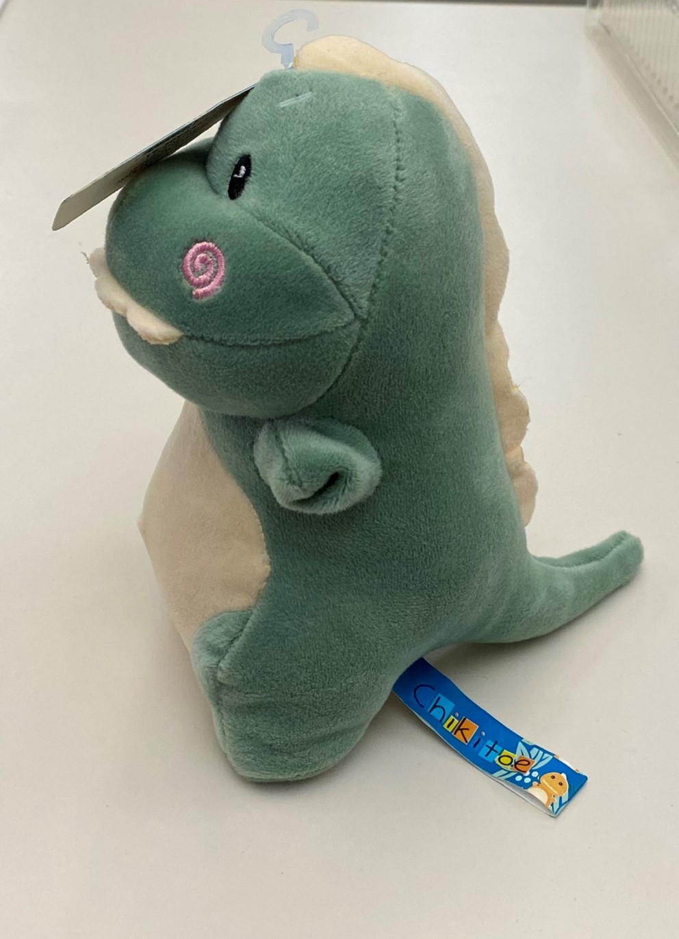 Imagen oficial de Chikitoe plush dinosaur with rattle publicada por OECD 2